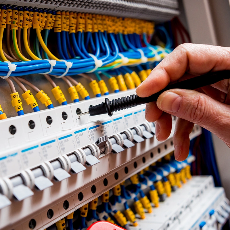 Électricien travaillant sur un tableau de distribution électrique.