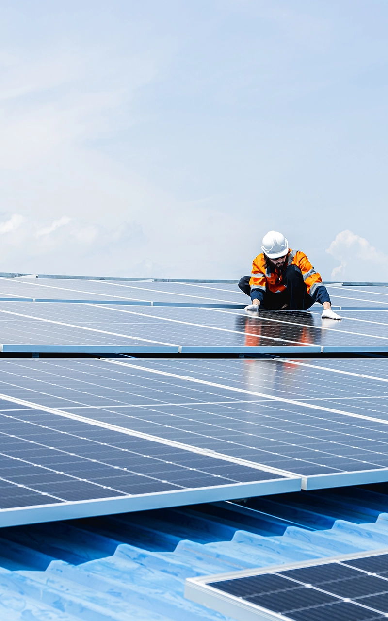 Installation de panneaux solaires sur un toit par un technicien.