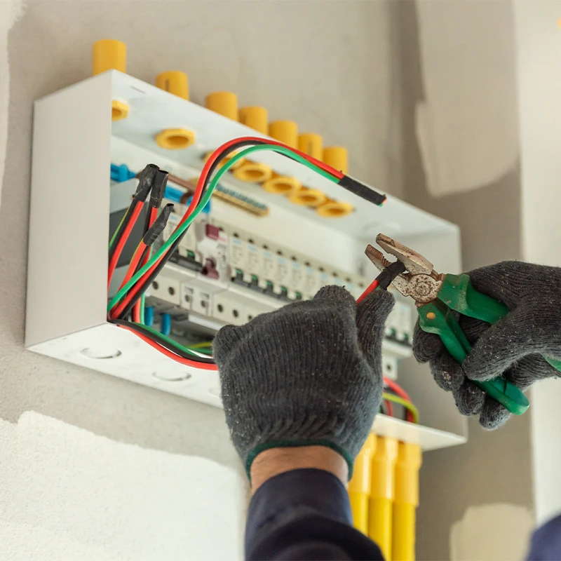 Électricien travaillant sur un tableau électrique dans une installation résidentielle