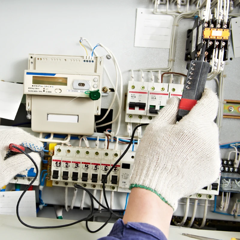 Technicien effectuant des tests électriques sur un tableau de distribution