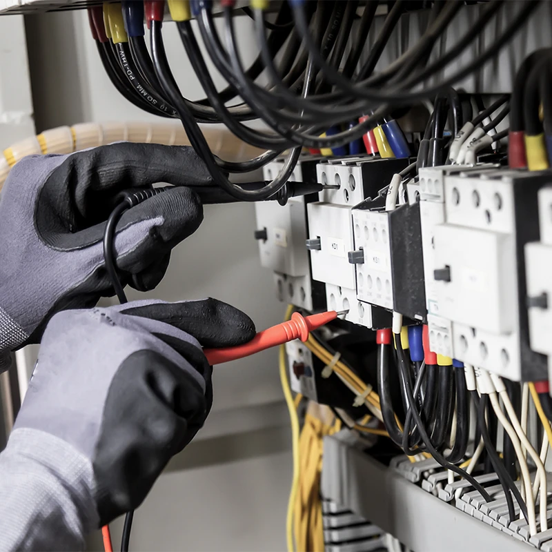 Électricien effectuant un test de courant sur un tableau de distribution