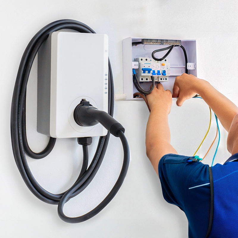 Boîtier de recharge pour véhicule électrique installé par un technicien.