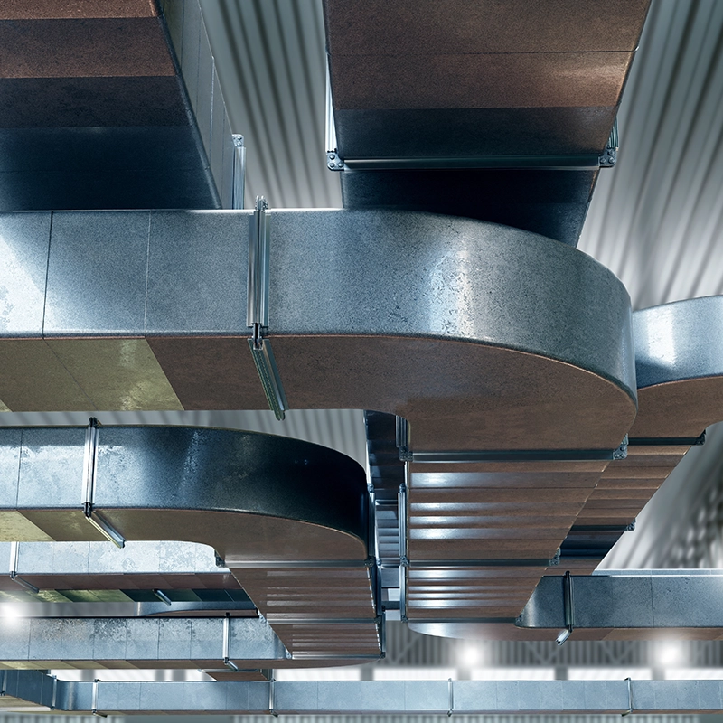 Système de conduits de ventilation en acier installés dans un bâtiment.